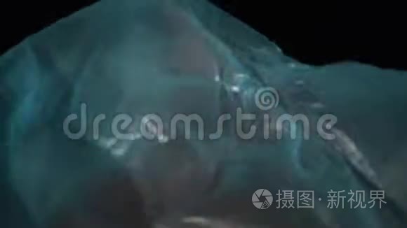 可爱的人在蓝色玻璃纸电影中模仿水做游泳动作