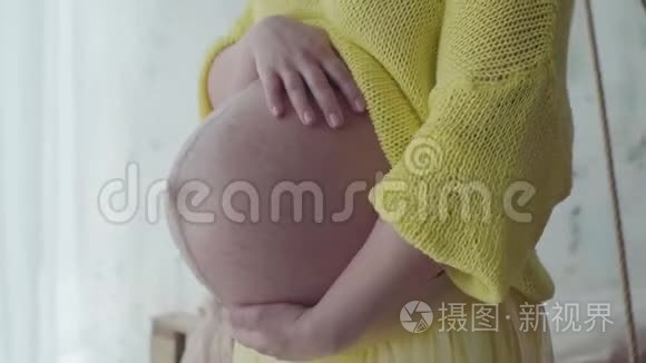 孕妇站在家时抱着肚子。 慢动作