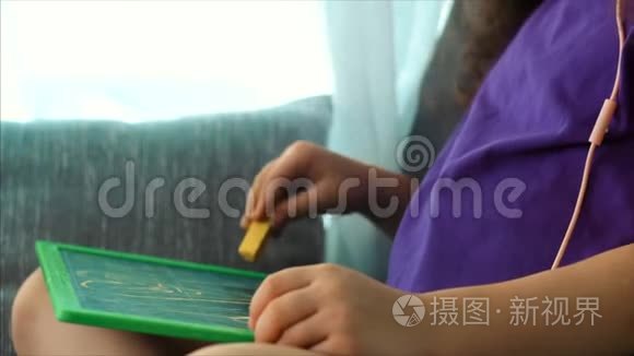艺术家的年轻双手，小儿童艺术家用石墨铅笔绘制画布，坐在桌子上画画布