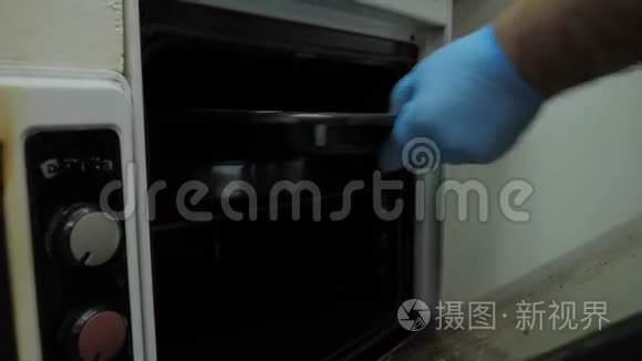 近景厨师手拿黑色烤纸从烤箱视频