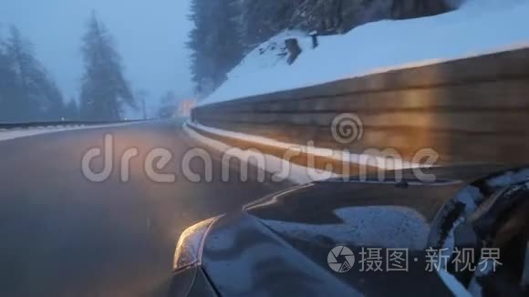 黑色现代汽车与前灯在道路上沿雪覆盖的山丘。