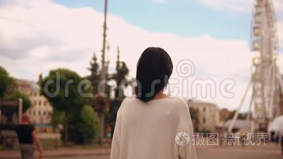一个女人在游乐场散步的后景视频