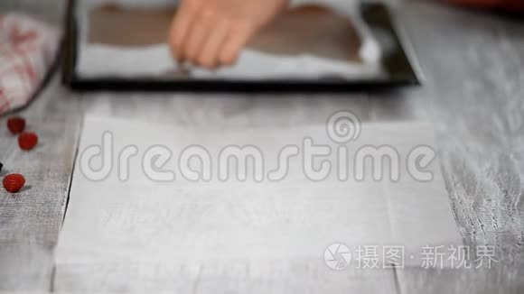 女性手从海绵蛋糕的底部剥离羊皮纸。
