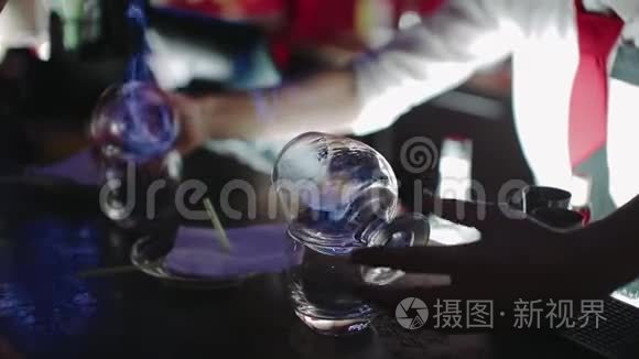 酒吧老板用火焰准备酒精鸡尾酒，酒吧柜台。 慢动作