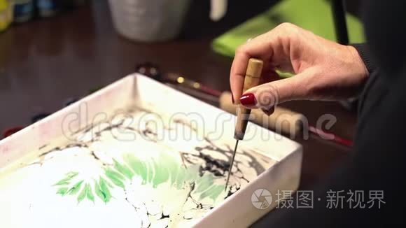 伊斯兰艺术-埃布鲁技术，在液体水面上绘画。纸大理石花纹。女人画笔，绿色和