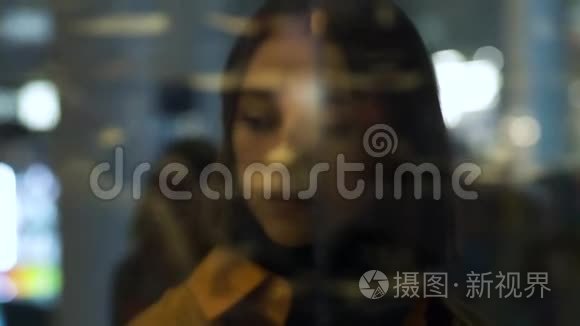 一个年轻的女模特透过窗户反射视频