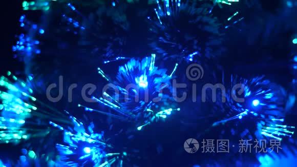 房间里的圣诞树闪耀着蓝色红色的灯光。 人造圣诞树上装饰着花环，发光