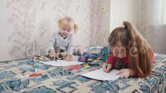 两个小女孩躺在床上画画