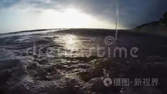 日落时波浪翻滚的岩石海岸视频