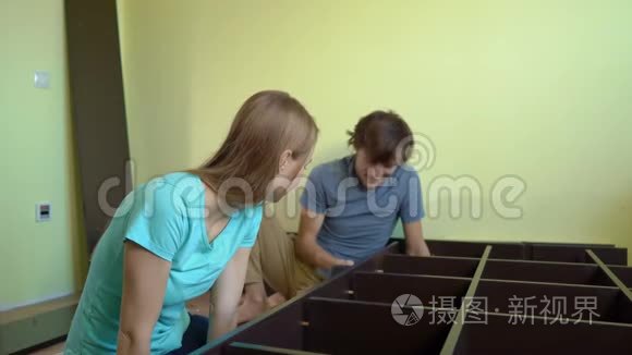 年轻的一家人用架子组装橱柜视频