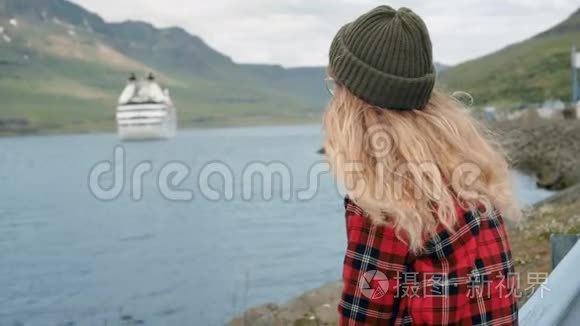 年轻女子坐在港口看游轮离开视频
