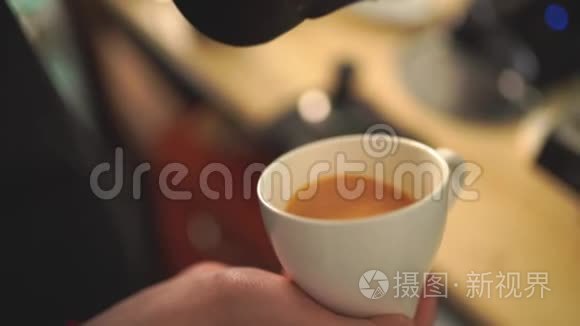 咖啡师将牛奶倒在咖啡上的慢动作创造出完美的卡布奇诺或拿铁