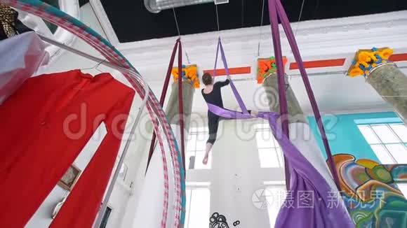 一名女子空中体操运动员在一个工作室里表演紫罗兰丝绸