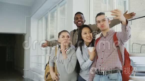 一群多民族的学生在大学走廊里站在智能手机相机上自拍。 偷鸡仔