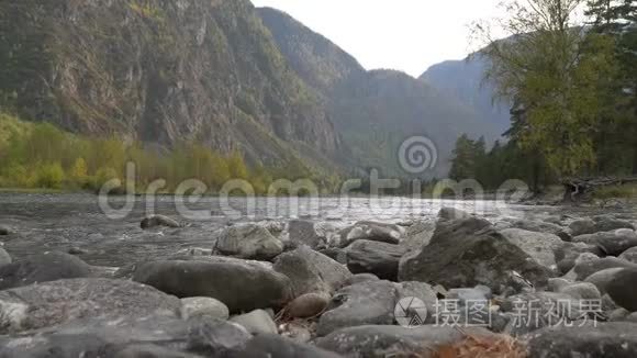 美丽的景观景观，山河溪流，岩石的河岸，森林和山峰在地平线上。