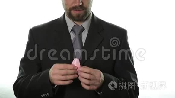 特写男人的手拿着粉红色的丝带。 乳腺癌意识。 保健和医学概念