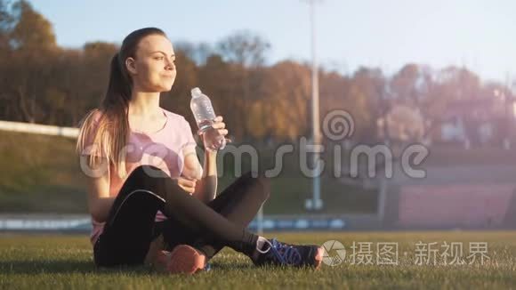 女孩在体育场喝水