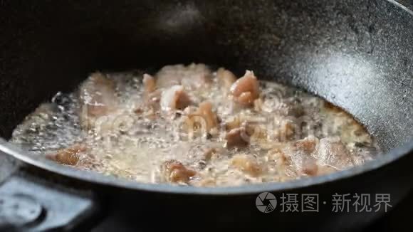 一个年轻女人的手在锅里用猪肉炒