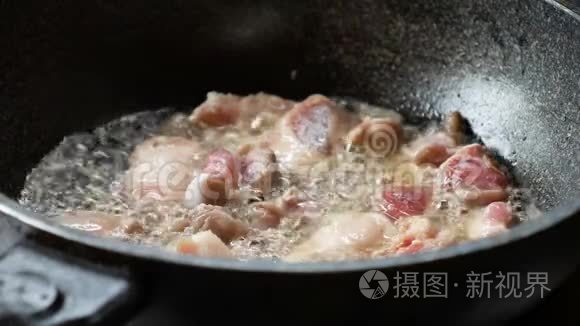 一个年轻女人的手在锅里用猪肉炒