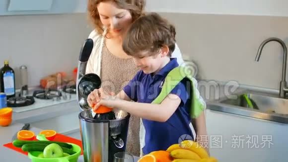 年轻的白种人母亲和孩子在厨房用电榨汁机制作鲜橙果汁