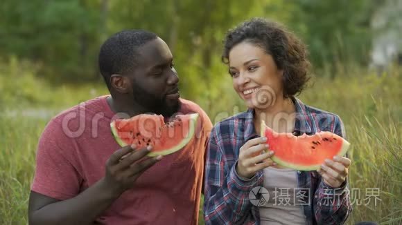 快乐的一对夫妇享受美味的西瓜大片，有益的水果饮食