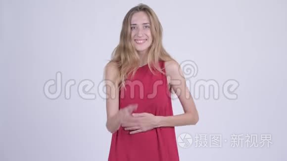 快乐的年轻美丽的金发女郎笑着指着镜头