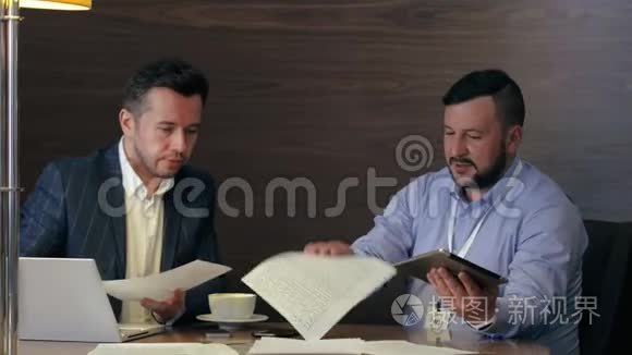 两位男企业家在办公室会议上喝咖啡时交谈