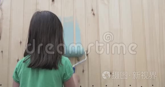小女孩用滚筒画小木屋