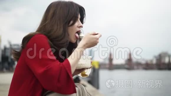 一位美丽的年轻女子夏天在德国街头吃饭，潘射球