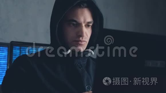 在黑暗的办公室里用电脑工作的男黑客。 在Stealam上开枪