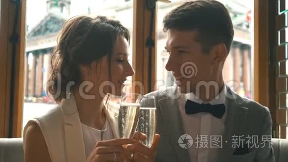 新婚夫妇在餐厅亲吻并喝香槟