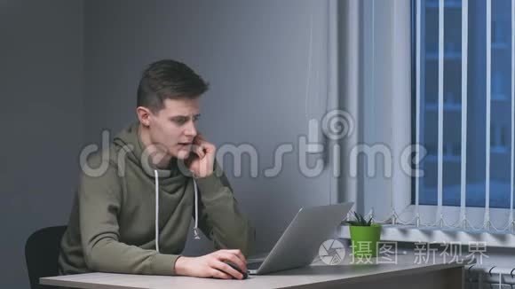 年轻的商人晚上在用笔记本电脑工作