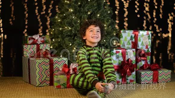 可爱的孩子兴奋地坐在圣诞树前视频