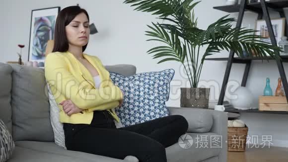 头痛的休闲妇女在家坐在沙发上视频
