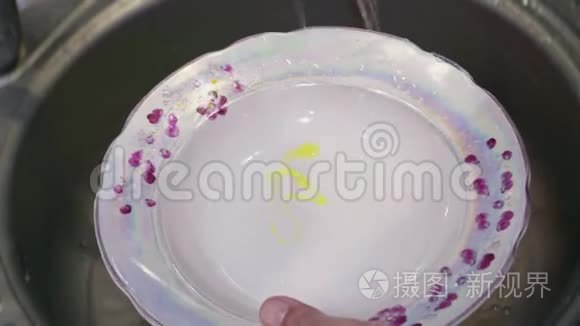 一个盘子用清洁剂在水槽里洗干净