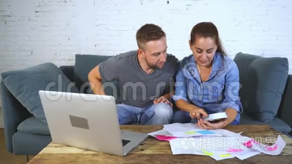年轻的幸福夫妇用笔记本付账单视频