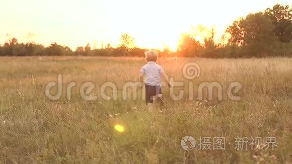 日落时分，小男孩在田野上奔跑，慢悠悠