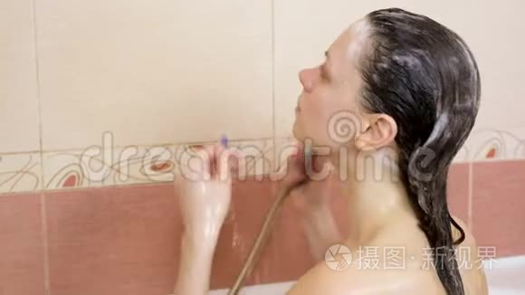 布鲁内特女士在浴缸里洗头发。 特写的头，肩膀..