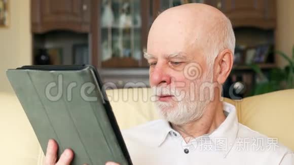 现代老人在家使用平板电脑，浏览，阅读新闻.. 退休后积极的现代生活