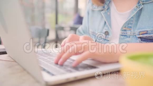 商业自由职业亚洲妇女工作，做项目和发送电子邮件笔记本电脑或电脑，而坐在桌子上的咖啡馆。
