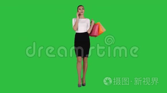 购物的女人拿着袋子在绿色屏幕上打电话，铬钥匙。