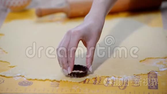 烹饪和家庭概念-关闭女性手制作饼干从新鲜面团在家里。