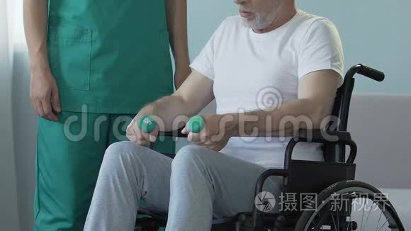 老人坐在轮椅上，拿着哑铃，和护士说话，恢复正常
