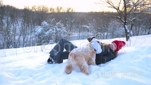 女孩躺在雪地上拥抱她的狗视频