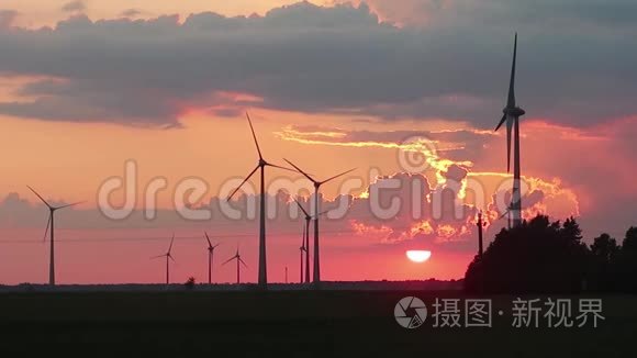 风力涡轮机在日落时在田野里旋转。