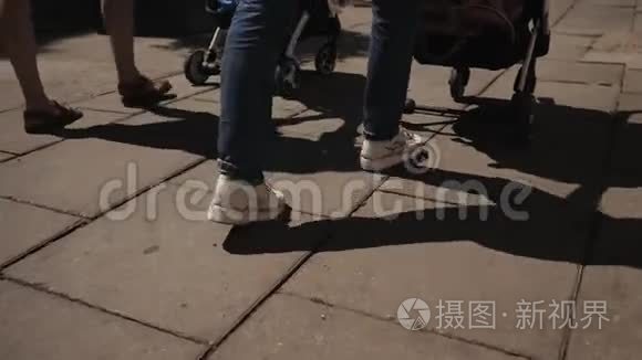 年轻快乐的母亲带着婴儿车的女人走在街上，说话散步