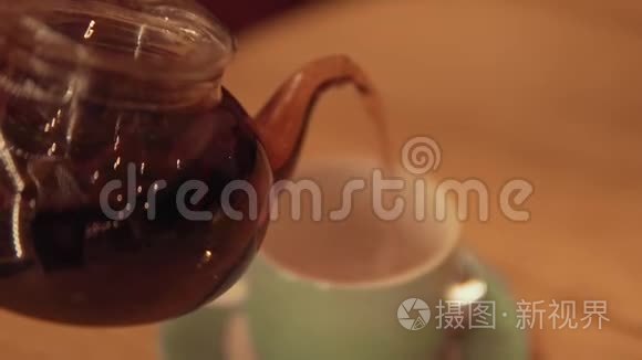 喝茶。 将茶倒入玻璃透明茶杯中