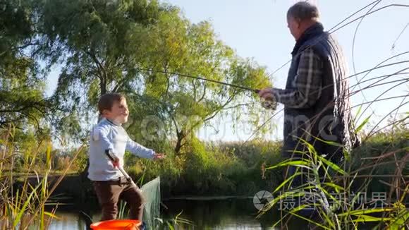 秋天的休息，鲫鱼在钓竿上交到爷爷手中，和男孩在水道上的大自然