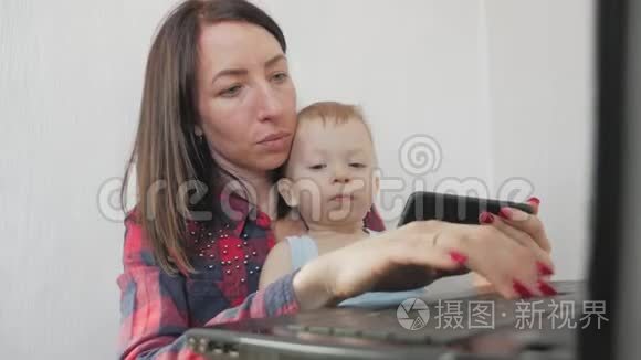 多任务自由职业和母性概念在家工作的母亲小男孩和笔记本电脑。 家庭母亲