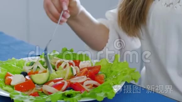 有用的食物，女性面前桌子上的蔬菜沙拉和叉子